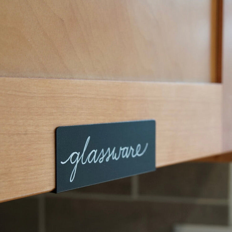 Black clip labeling a glassware cabinet