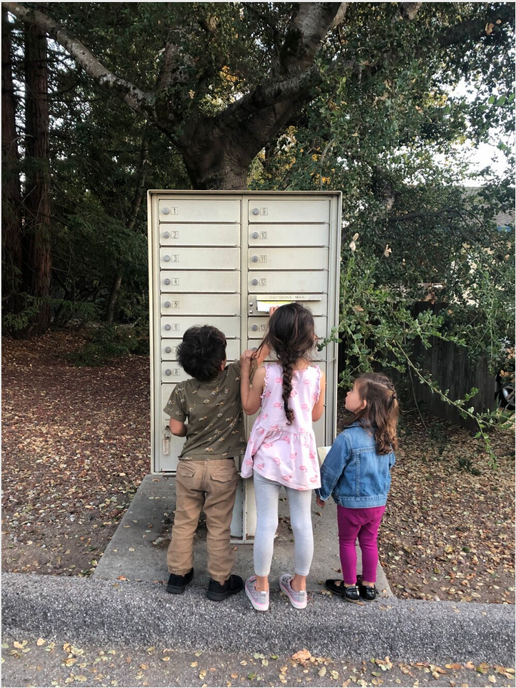 Three kids mailing a TidyPop order at a neighborhood mailbox