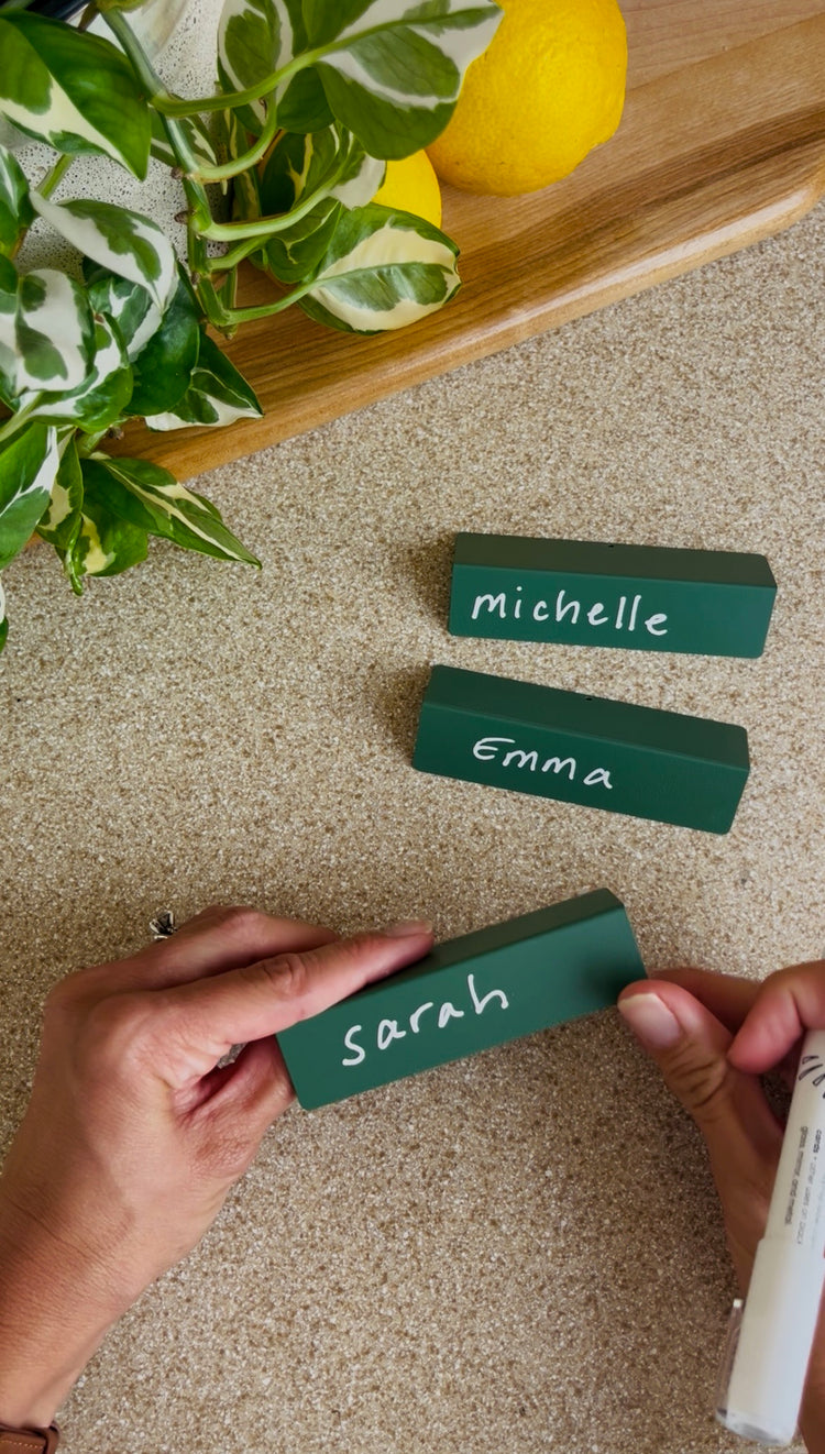 Writing names on green place cards with a TidyPop marker